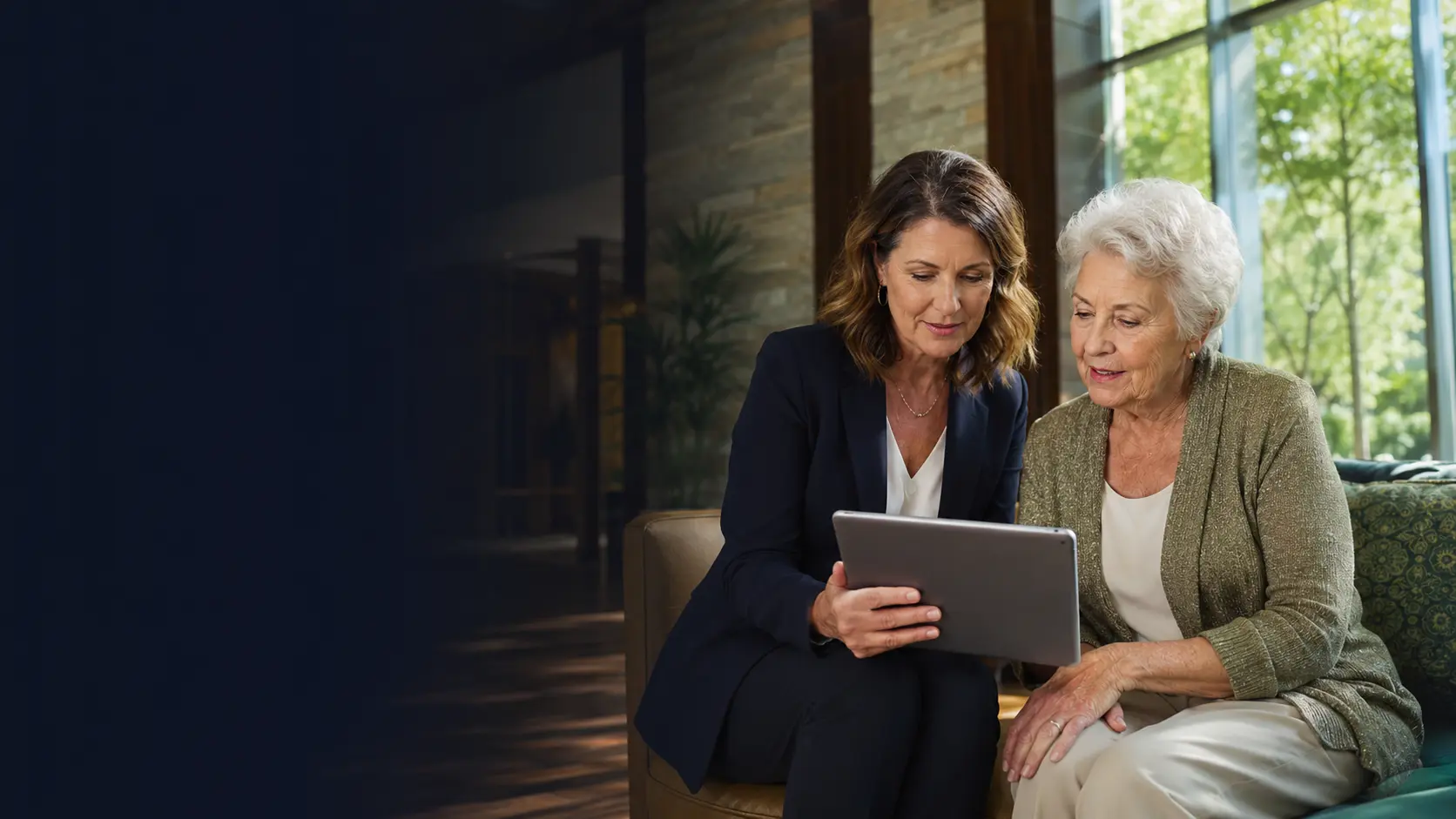 Senior-living administrator helping a resident use a tablet in a modern community